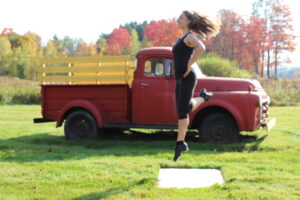 Irish step dancer in front of old truck